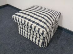 A footstool upholstered in a checkered fabric