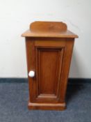 An antique pine bedside cabinet with ceramic handle
