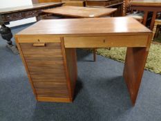 A mid century teak shutter fronted desk