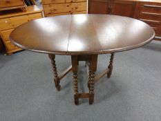 A reproduction oak gate leg table