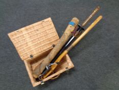 An ornamental Samurai sword together with a paddle, a rain stick and a wicker case, catapult,