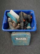 A plastic crate containing various power tools including Makita drill,