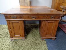 An Edwardian oak pedestal desk