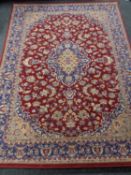 A machine made Kashan design carpet on red ground