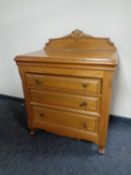 A contemporary light oak three drawer chest
