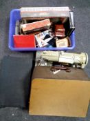 A box containing vintage puzzles and games, vintage tins, together with a suitcase, oil on board,