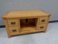 A contemporary oak entertainment stand fitted four drawers