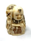 A carved Chinese bone netsuke - Village elder carrying a large bag