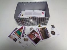 A box containing approximately 30 Royal Commemorative Coin First Day covers