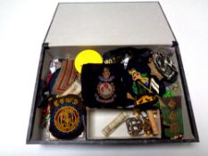 A box containing a large quantity of assorted militaria including badges and insignia, buttons,