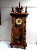An Edwardian Vienna style wall clock with brass and painted dial, pendulum and key.