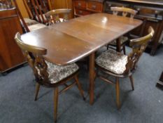 An Ercol elm and beech drop leaf table together with a set of four chairs