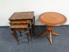A nest of three walnut pie crust edge tables together with an inlaid yew wood wine table