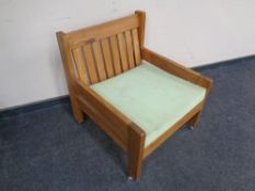 A 1970's teak low backed armchair