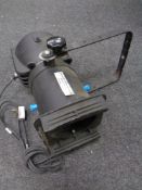 A theatre light on telescopic stand together with three drum kit stands.