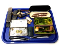 A tray containing two cut throat razors, pipes, cased pen set, cheroot, pocket knives,
