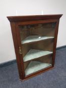 A nineteenth century glazed door hanging corner cabinet