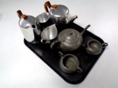 A three piece English pewter tea service and four piece Piquot ware tea service