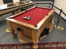 A 'Geordie' branded pool table, set of balls, triangle, four cues and extension.