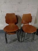 Seven assorted Danish teak stacking chairs on metal legs