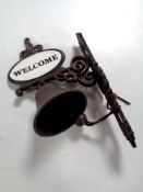 A cast iron welcome wall bracket with bell