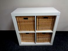 A white Ikea storage unit with four wicker baskets