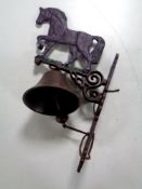 A cast iron wall bracket horse with bell