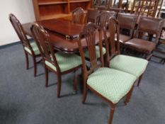 A Regency style inlaid mahogany extending dining table with leaf on brass capped feet together with