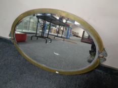 An antique oval brass framed bevel edged mirror