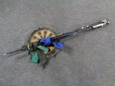 Three fly fishing rods together with a spinning rod and a dart board
