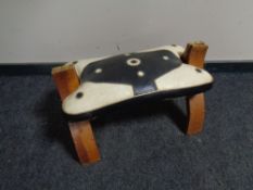 A camel stool with leather saddle