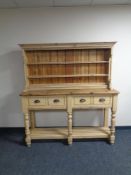 A stripped pine kitchen dresser fitted four drawers beneath with undershelf