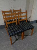 A set of four blond oak ladder back chairs