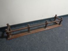An Edwardian oak bobbin fire curb