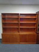 A pair of mid 20th century Danish teak veneered bookshelves fitted cupboards beneath