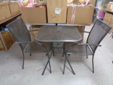 A metal patio table together with three armchairs