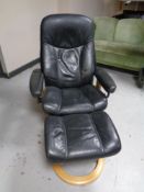 An Ekornes stressless leather armchair with matching footstool (black)