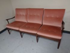 A late 20th century stained beech framed three seater settee upholstered in a pink dralon
