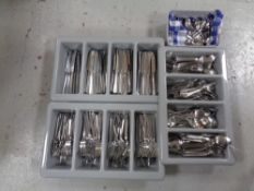 Three cutlery trays and a basket containing a large quantity of stainless steel catering cutlery