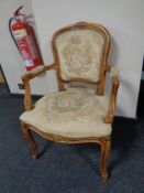 A carved beechwood French salon armchair upholstered in a tapestry fabric
