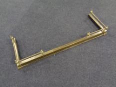An antique brass telescopic fire curb