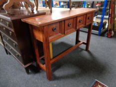 A stained pine hall table fitted four drawers