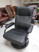 A late 20th century swivel armchair upholstered in black leather