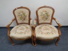 A pair of carved beech French salon armchairs upholstered in a tapestry fabric