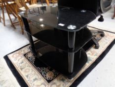 A black glass three tier LCD TV stand