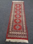 A fringed Bokhara design runner,