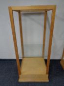 A square oak shop display stand with two glass shelves