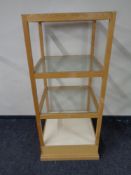 A square oak shop display stand with three glass shelves