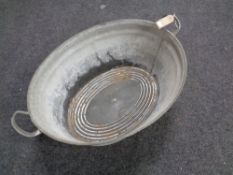 A galvanized twin-handled wash tub