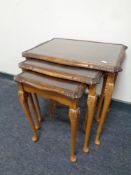 A nest of three glass topped tables